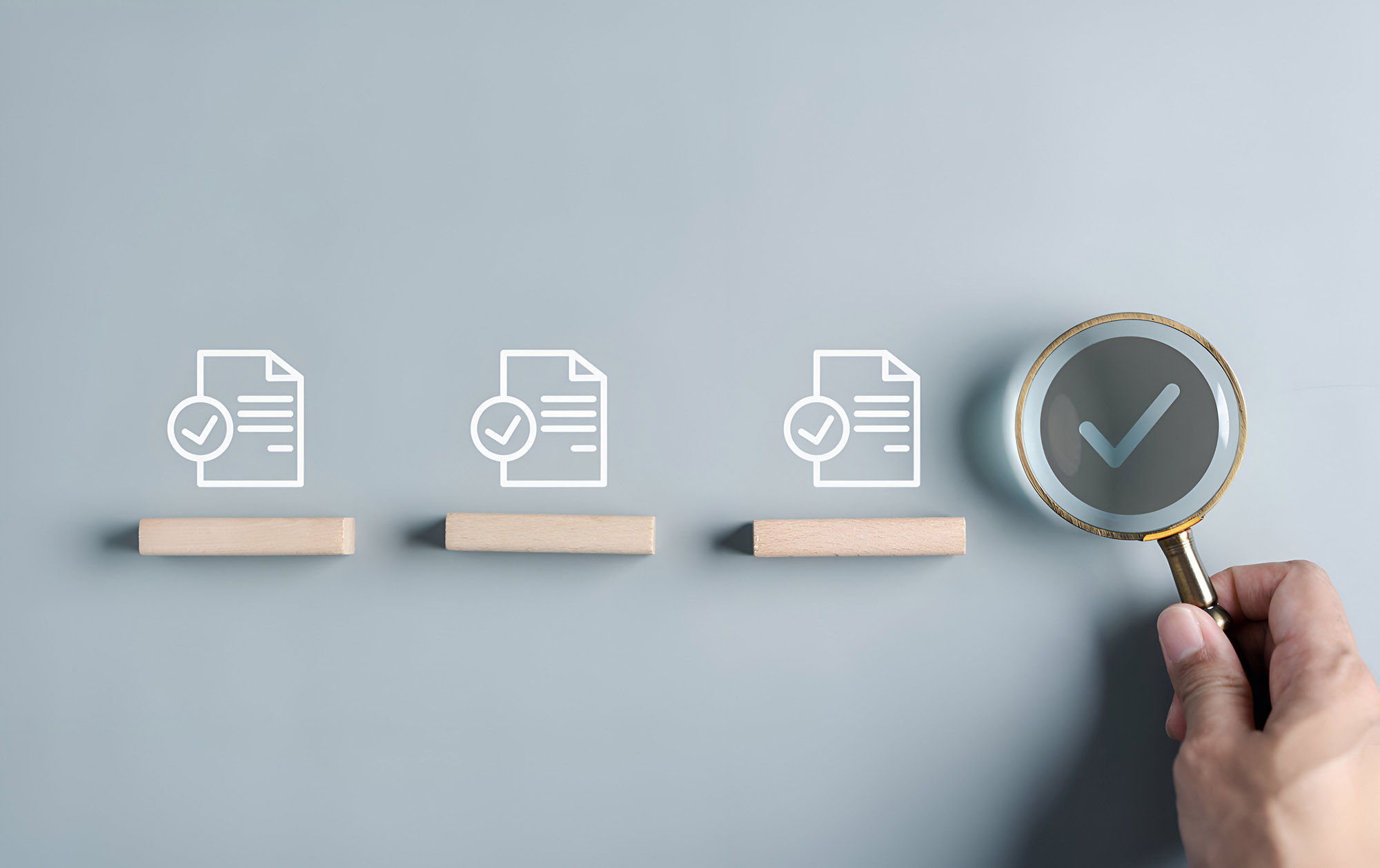 На изображении четыре иконки документов с галочками и одна лупа, которая увеличена и показывает галочку.
